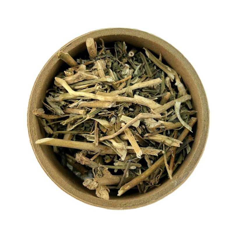 Dried rue flowers and stems in a round bowl against a white background.