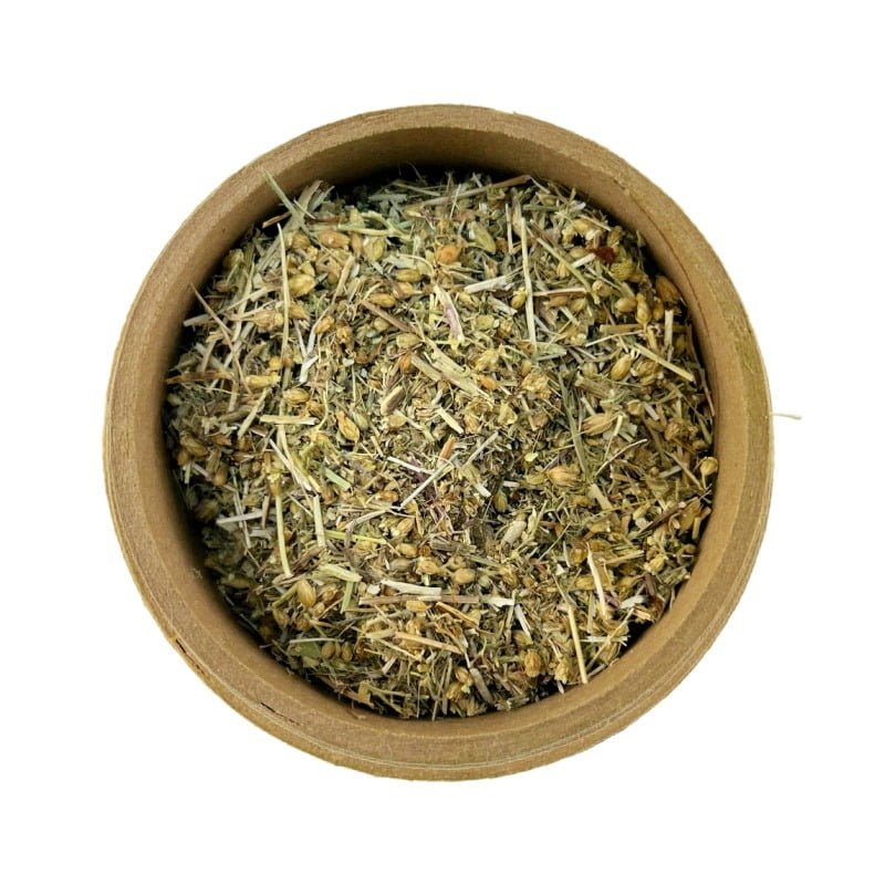 A top view of a round bowl filled with dried yarrow herb on a white background.