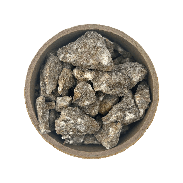 Benzoin resin in a brown bowl set on a white back ground.