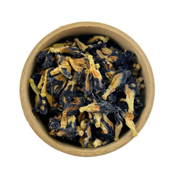 A bowl filled with dried blue and yellow butterfly pea flowers, viewed from above against a white background.