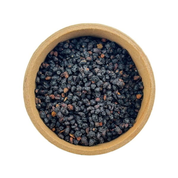 A wooden bowl filled with black dried berries, viewed from above on a white background.
