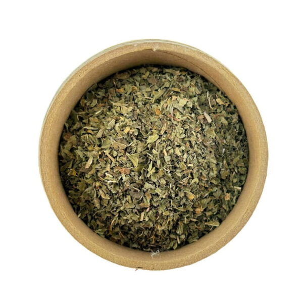 Top view of dried peppermint leaves in a round wooden bowl on a white background.