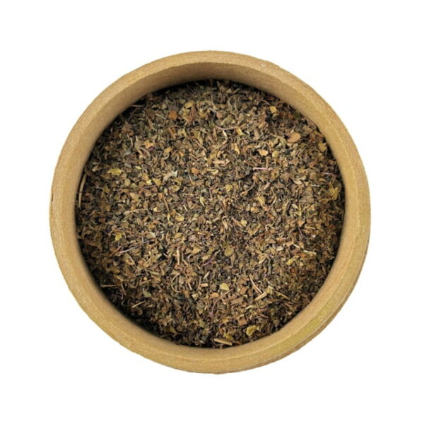 A top-down view of a round wooden container filled with ground tulsi (holy basil) herb.